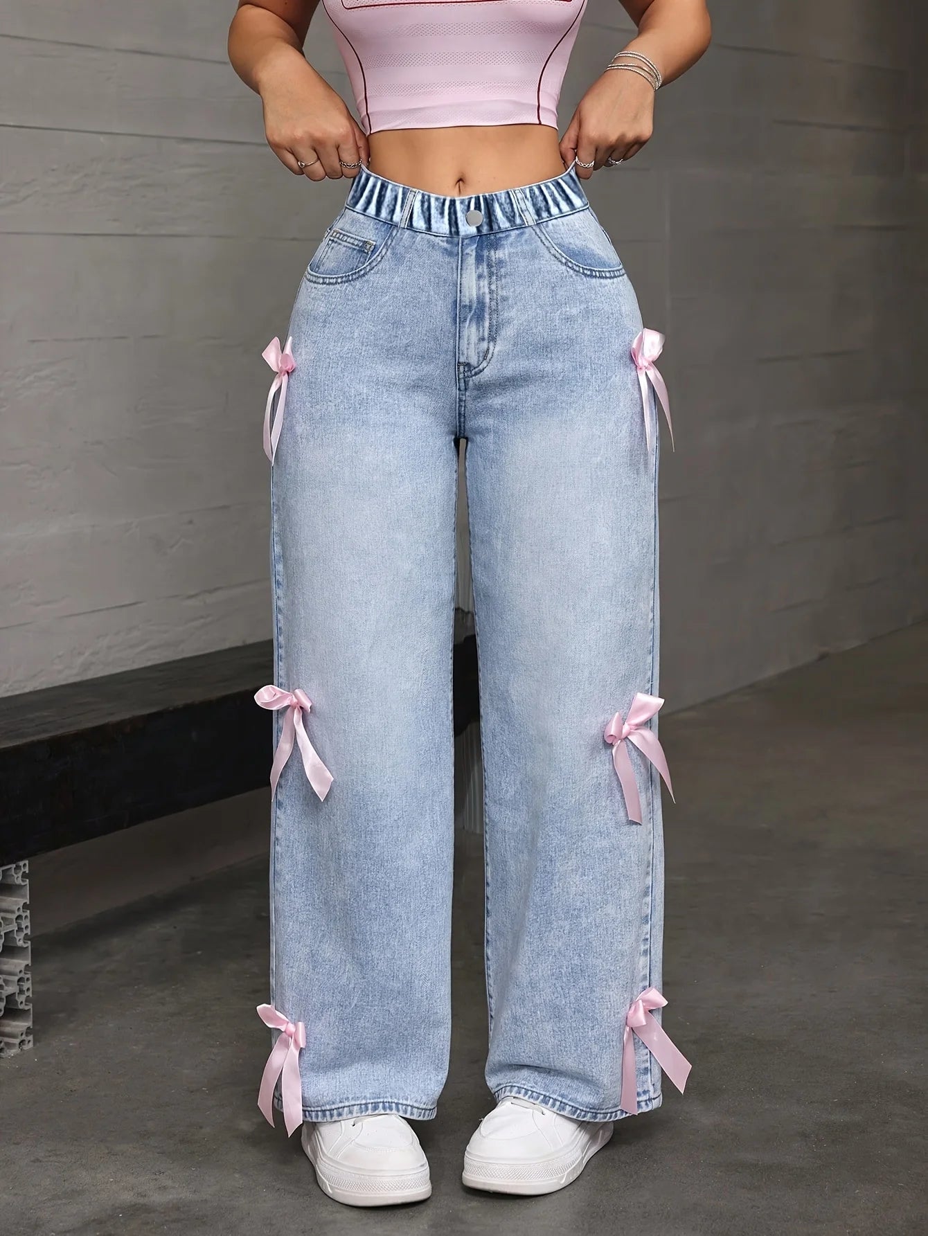 Teenage girl's Y2K loose straight wide jeans, with a pink bow pattern on the side, for street dance performances.