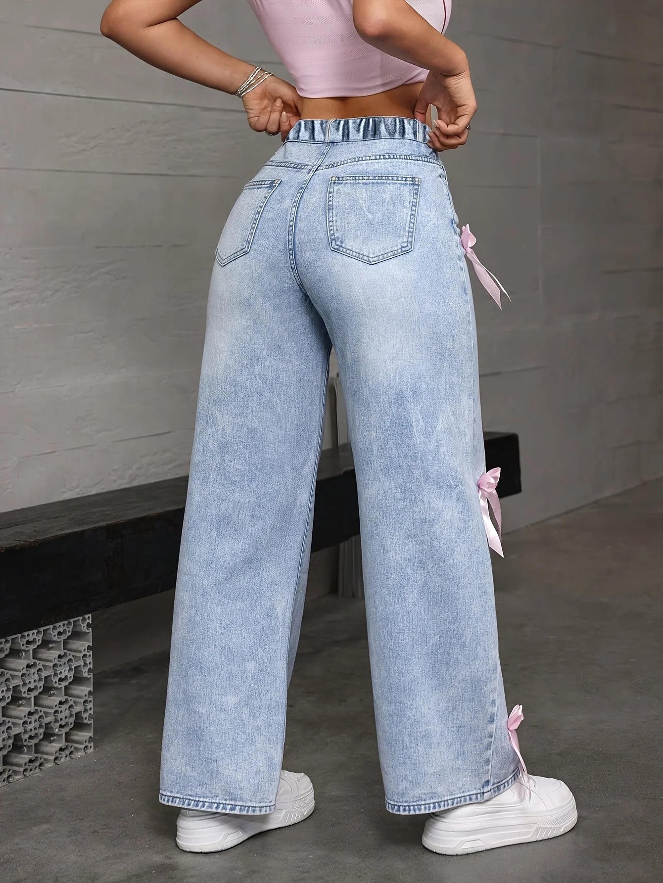 Teenage girl's Y2K loose straight wide jeans, with a pink bow pattern on the side, for street dance performances.